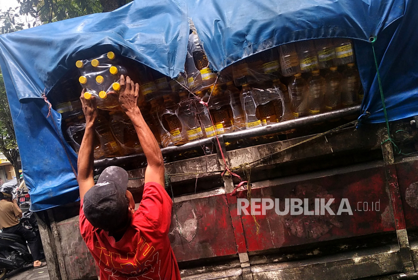 Pekerja mengambil Minyakita untuk didistribusikan ke pedagang sembako di Pasar Beringharjo, Yogyakarta, Kamis (16/2/2023). Kementerian Perdagangan (Kemendag) mengungkap adanya praktik pemalsuan minyak goreng merek Minyakita dan dijual di atas harga Rp 14 ribu per liter.