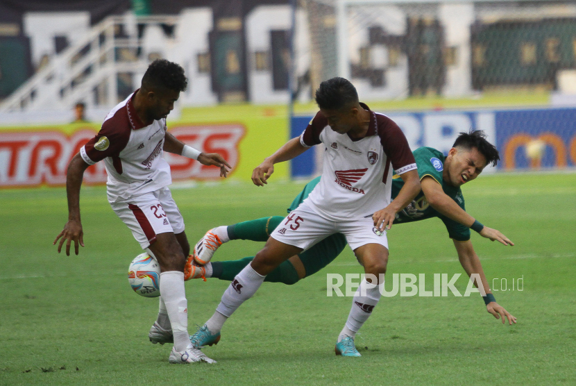 Pesepak bola Persebaya Muchamad Wildan Ramdhani (kanan) terjatuh saat berusaha melewati pesepak bola PSM Yance Sayuri (kiri) dan Akbar Tanjung (tengah) pada pertandingan Liga 1 di Stadion Gelora Bung Tomo, Surabaya, Jawa Timur, Jumat (18/8/2023). Persebaya mengalahkan PSM dengan skor 1-0.  