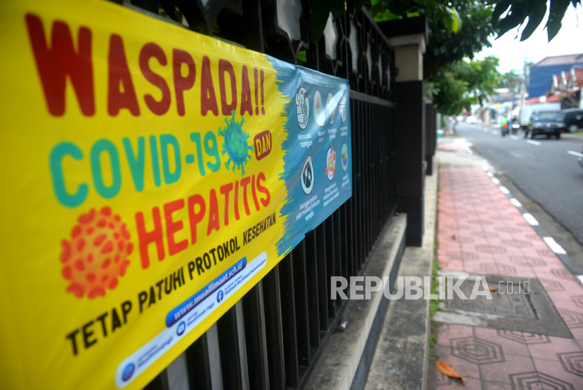 Spanduk himbauan waspada terhadap Covid-19 dan Hepatitis terpasang di depan Madrasah Muallimat, Yogyakarta, Jumat (20/5/2022). Organisasi Kesehatan Dunia (WHO) terus memantau laporan hepatitis misterius yang menyerang anak-anak di seluruh dunia.
