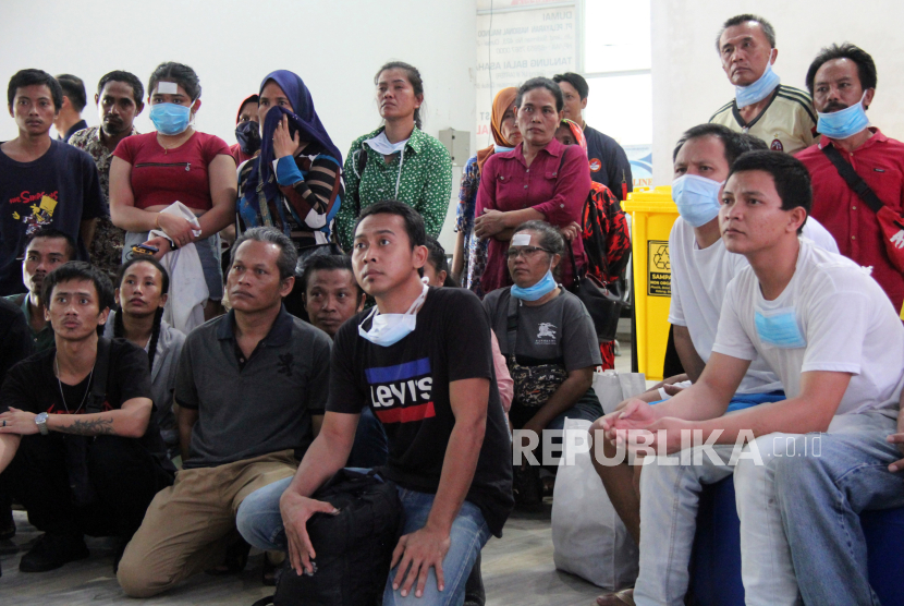 Sejumlah pekerja migran yang dideportasi secara mandiri dari Malaysia mendengarkan pengarahan dari petugas di Terminal Penumpang Pelabuhan Pelindo Dumai, Riau, Ahad (24/3/2024).