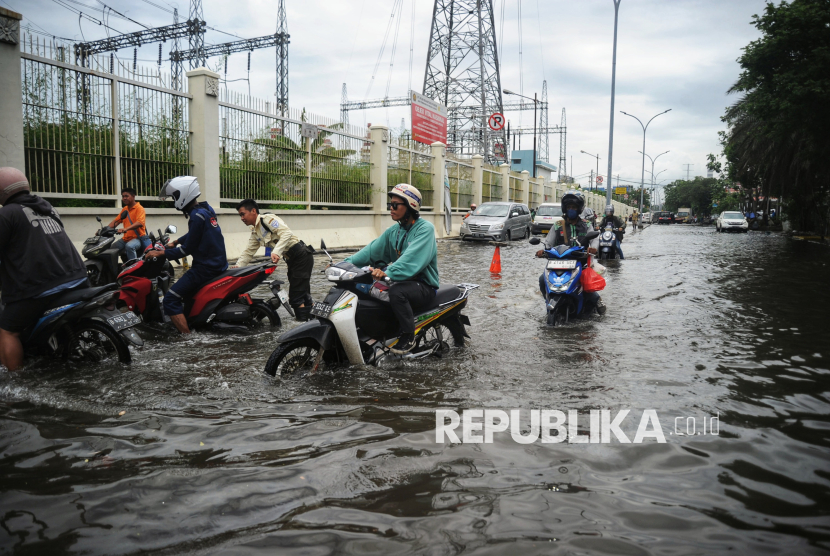 Pengendara motor melintasi banjir rob di kawasan Pluit Karang Ayu Barat, Kecamatan Penjaringan, Jakarta Utara, Senin (16/12/2024).