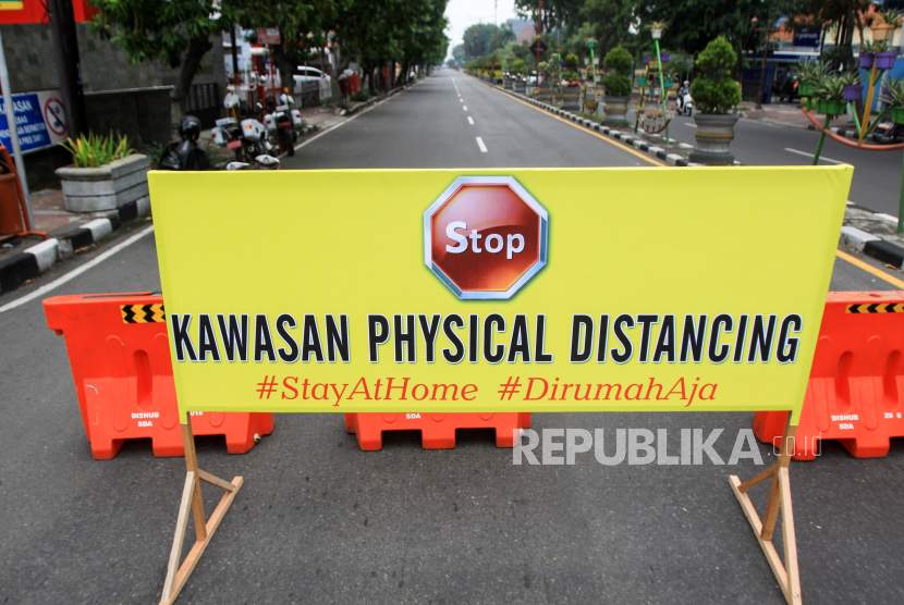 Pengendara melintas di Jalan Ahmad Yani, Sidoarjo, yang ditutup untuk menegakkan program physical distancing.