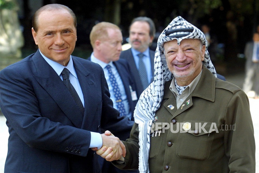 Presiden Palestina Yasser Arafat (kanan) berjabat tangan dengan PM Italia  Silvio Berlsconi di Roma. 