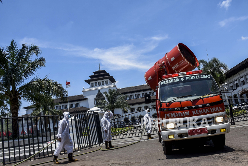 Petugas dari Dinas Kebakaran dan Penanggulangan Bencana (Diskar PB) Kota Bandung melakukan penyemprotan disinfektan menggunakan mobil gunner spraying di depan Gedung Sate, Jalan Diponegoro, Kota Bandung.