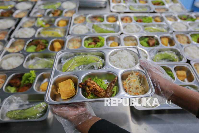 Petugas menyiapkan hidangan Makan Bergizi Gratis (MBG) sebelum didistribusikan ke sejumlah sekolah di dapur Satuan Pelayanan Pemenuhan Gizi (SPPG) Sumedang Cimanggung Mangunarga, Sumedang, Jawa Barat, Selasa (18/11/2025).
