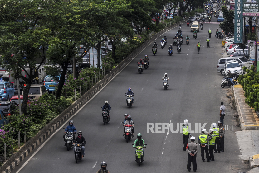 Anggota kepolisian mengatur lalu lintas di Jalan Raya Margonda, Depok, Jawa Barat
