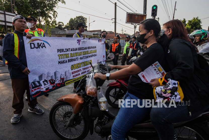 Petugas KAI Commuter bersama relawan melakukan sosialisasi keselamatan di perlintasan sebidang Stasiun Pondok Jati, Matraman, Jakarta Timur.