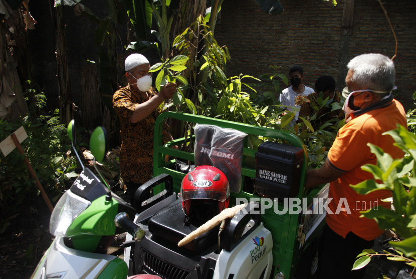 Warga bergotong-royong mengambil bibit pohon buah untuk ditanam saat peresmian Kampung Buah Karangasem, Laweyan, Solo, Jawa Tengah, Selasa (24/8/2021). Peresmian kampung buah setempat digelar sebagai program bulan penghijauan sekaligus merayakan HUT ke-76 RI. 