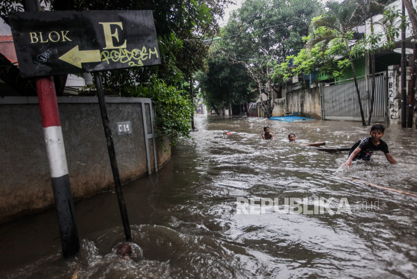 Anak-anak bermain air saat terjadi banjir di Pondok Karya, Mampang, Jakarta Selatan, Kamis (4/1/2024). Banjir setinggi 80 sentimeter tersebut diakibatkan hujan dengan intensitas tinggi di wilayah Jakarta Selatan hingga membuat aliran air dari Kali Krukut meluap.