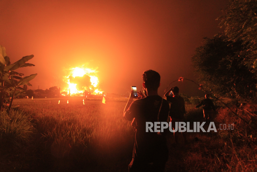 Warga menyaksikan kebakaran di kompleks Pertamina RU VI Balongan, Indramayu, Jawa Barat, Senin (29/3/2021) dini hari. ANTARA FOTO/Dedhez Anggara/pras.