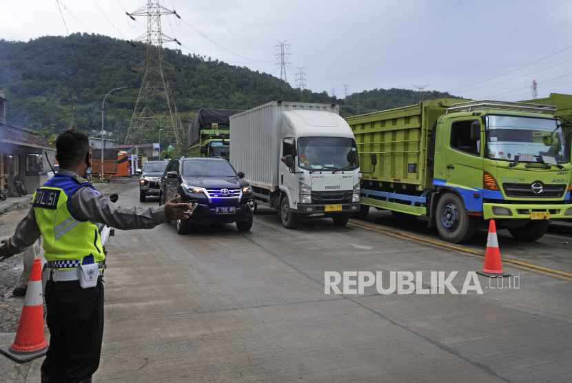 Personel polisi lalu lintas mengatur arus kendaraan yang akan menyeberang ke Pulau Sumatra di Pelabuhan Merak, Kota Cilegon, Provinsi Banten, Selasa (26/4/2022). 