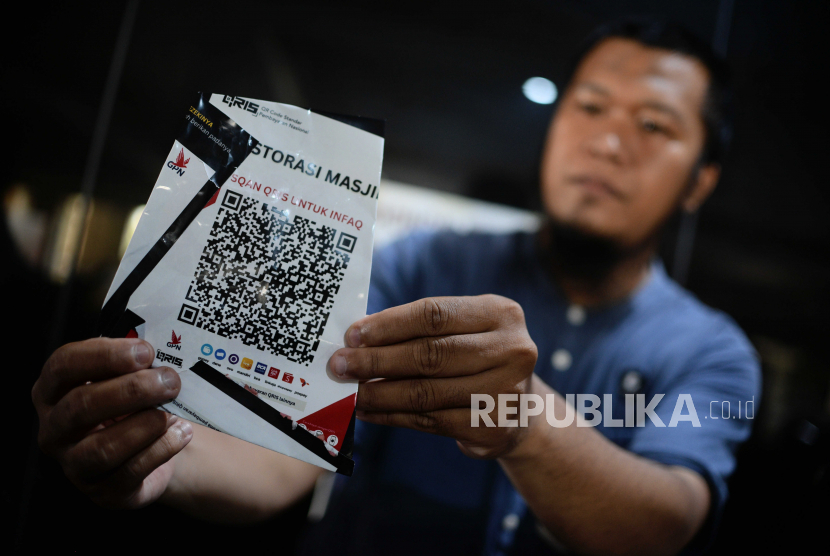 Pengurus masjid memperlihatkan stiker QRIS palsu yang mengatasnamakan untuk restorasi masjid di Masjid Nurul Iman Blok M Square, Kebayoran Baru, Jakarta, Senin (10/4/2023). Menurut pengurus masjid, sekitar 20 stiker QRIS palsu terpasang di Masjid Nurul Iman Blok M Square, yang ditempel pada kotak dan dinding masjid sejak Kamis (6/4/2023).