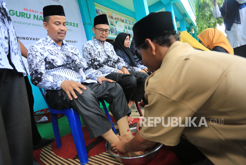 Sejumlah siswa-siswi membasuh kaki guru sebagai tanda penghormatan seusai upacara peringatan Hari Guru Nasional (HGN) 2022 di Madrasah Tsanawiyah Swasta (MTsS) Harapan Bangsa dan Madrasah Ibtidayah Negeri 11 Aceh Barat Desa Kuta Padang, Johan Pahlawan, Aceh Barat, Aceh, Jumat (25/11/2022). Rangkaian peringatan hari guru nasional di Aceh dikemas dengan aksi berbakti kepada guru seperti membasuh kaki guru dan menyuapkan nasi kepada guru dengan tujuan untuk menanamkan rasa hormat kepada guru yang telah memberikan bimbingan serta ilmu pengetahuan dalam memajukan dan meningkatkan pendidikan di Indonesia. 