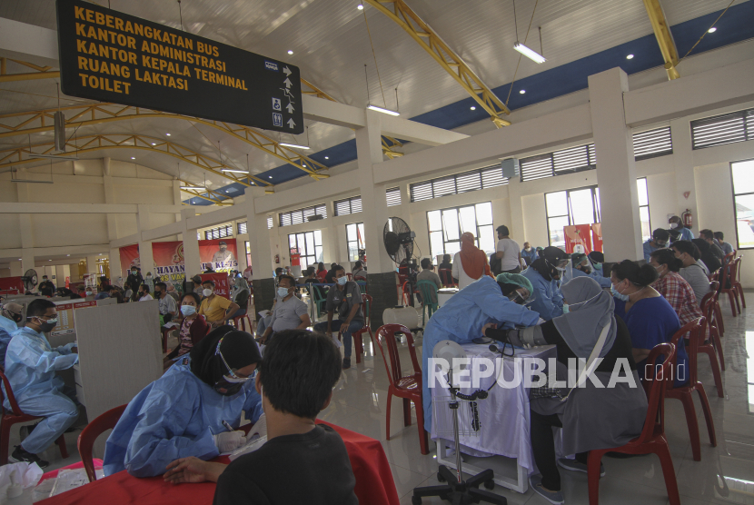 Petugas medis memeriksa kesehatan warga saat vaksinasi COVID-19massal di Terminal Jatijajar, Depok, Jawa Barat, Jumat (25/6/2021). Kasus covid-19 di Depok terus meningkat.