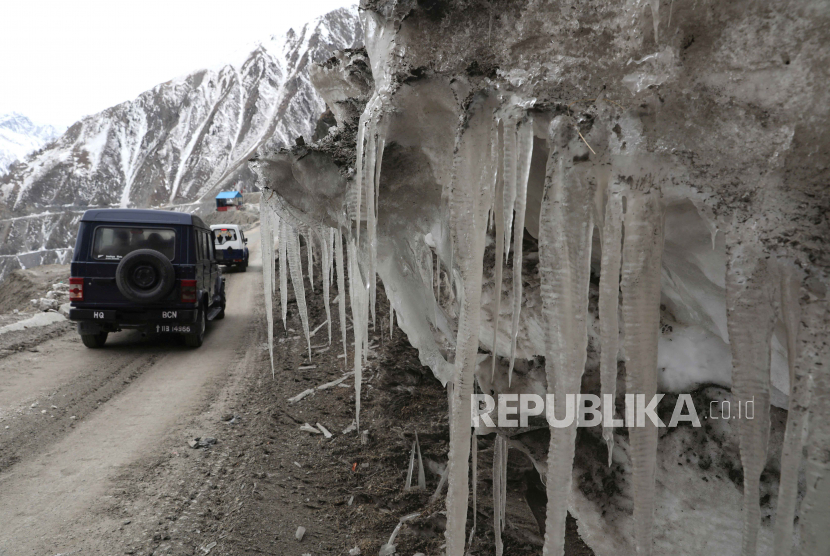 Kendaraan melewati es yang tergantung di pegunungan yang tertutup salju (ilustrasi)