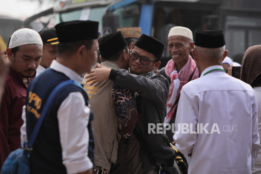 Jamaah haji menyalami petugas saat tiba di Asrama Haji Kota Tangerang, Banten, Rabu (5/7/2023). Sebanyak 391 jamaah haji kloter pertama Tangerang tiba kembali di tanah air usai menunaikan ibadah haji.
