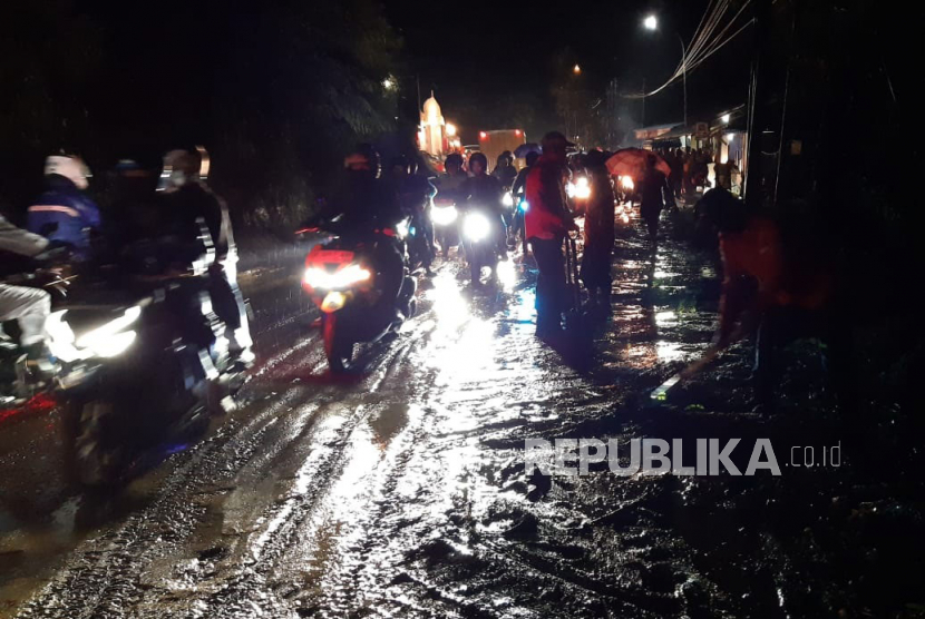 Pengguna kendaraan melintasi ruas jalan jalur Garut-Tasikmalaya di wilayah Desa Kutawaringin, Kecamatan Salawu, Kabupaten Tasikmalaya, yang sempat terdampak longsor, Senin (24/4/2023) malam. 