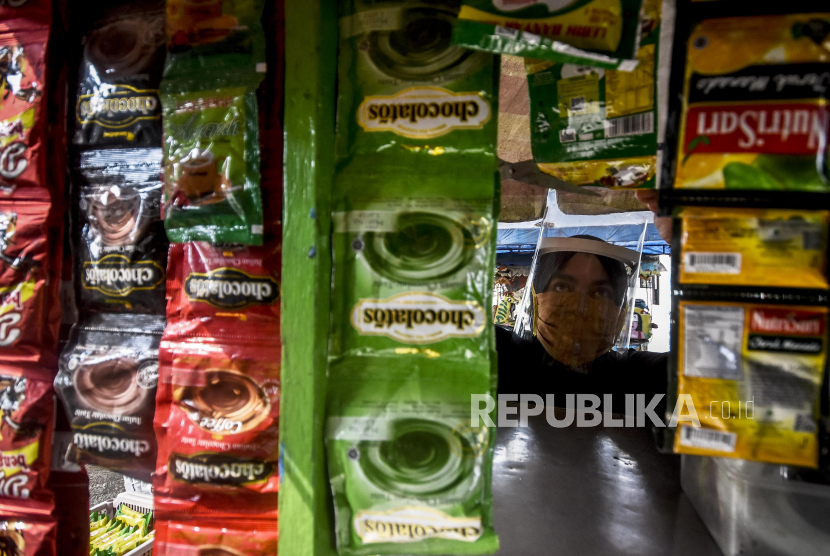Pedagang mengenakan masker dan pelindung wajah melayani pembeli di kawasan Jalan Kapten Tata Natanegara, Kota Bandung, Rabu (10/6). Sejumlah pedagang di kawasan tersebut menerapkan protokol kesehatan jelang new normal atau adaptasi kebiasaan baru (AKB), sekaligus sebagai upaya pencegahan virus Corona (Covid-19)