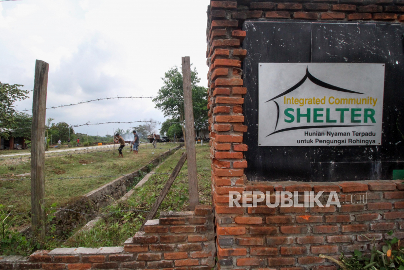 Sejumlah  pekerja menyelesaikan pembangunan pagar pemisah antar barak hunian bekas shelter  etnis Rohingya di Desa Blang Ado, Kuta Makmur, Aceh Utara, Aceh, Senin (30/3/2020). Pemerintah setempat menjadikan penampungan terpadu atau Integrated Community Shelter (ICS) yang dibangun Aksi Cepat Tanggap (ACT) dan International Organization for Migration (IOM) menjadi tempat isolasi masyarakat yang terjangkit COVID-19 guna menekan penyebaran virus lebih luas di kabupaten itu