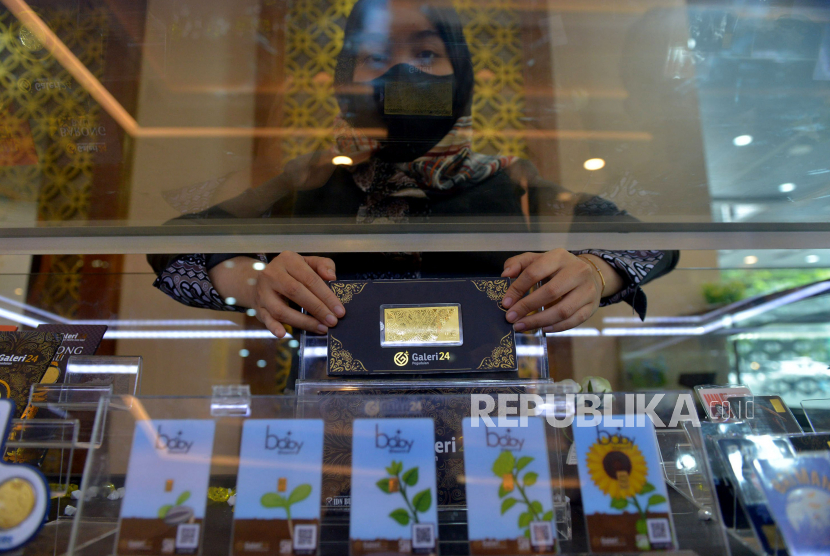 Pegawai menunjukkan emas Pegadaian di Galeri 24 Pegadaian, Jakarta, Senin (26/12/2022). Harga emas diprediksi akan terus mengalami kenaikan hingga akhir tahun 2022 dan 2023 ini. Ada banyak faktor yang mendorong logam mulia tersebut terus menguat salah satunya masalah ekonomi. Republika/Prayogi
