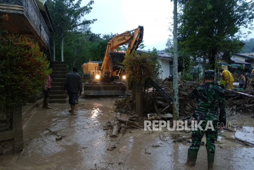 Alat berat yang dikerahkan Badan Penanggulangan Bencana Daerah (BPBD) dibantu aparat TNI dan Polri membersihkan jalan dan rumah warga dari material kayu dan batu akibat banjir bandang di Desa Paya Tumpi Baru, Kecamatan Kebayakan, Aceh Tengah, Aceh, Rabu (13/5/2020). Banjir bandang akibat tingginya intensitas hujan sejak sepekan terakhir telah merusak puluhan unit rumah warga di desa tersebut