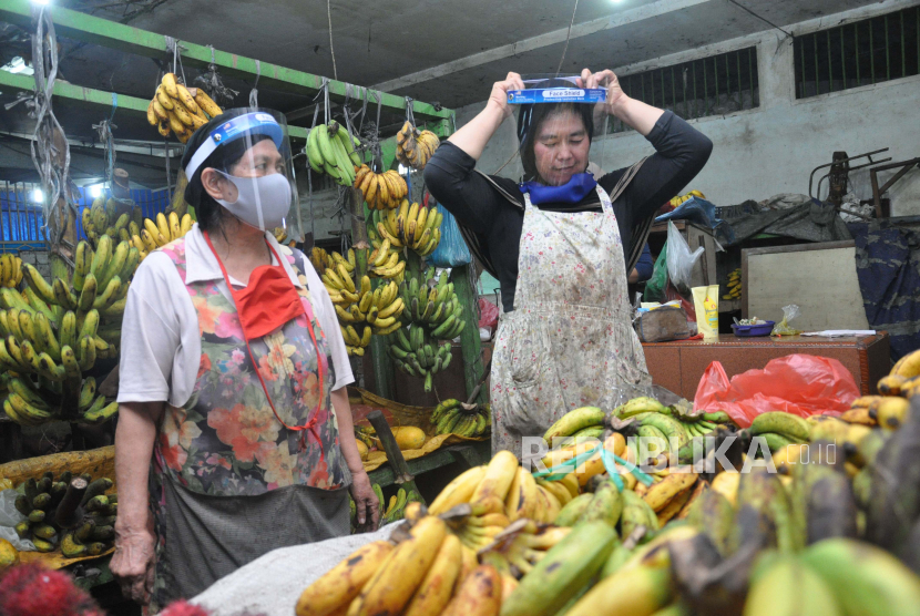 Pedagang memakai pelindung wajah saat sosialisasi penerapan adaptasi kebiasaan baru di pasar tradisional Petisah Medan, Sumatra Utara, Jumat (17/7/2020). Jumlah kasus Covid-19 di Sumatra Utara bertambah 42 pada Selasa (21/7).