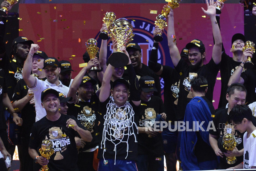 Pemain Pelita Jaya Jakarta Andakara Prastawa mengangkat trophy juara seusai mengalahkan Satria Muda Pertamina pada pertandingan ketiga final IBL 2024 di Indoor Stadium Sport Centre, Kabupaten Tangerang, Banten, Ahad (4/8/2024). Pelita Jaya Jakarta berhasil meraih gelar juara usai mengalahkan Satria Muda Pertamina dengan skor 73-65.