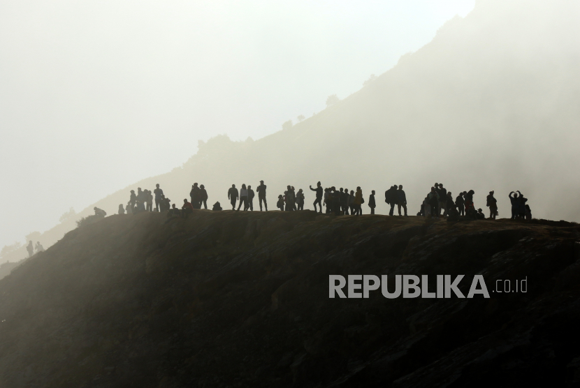 Pengunjung melihat kawah dari kaldera Gunung Ijen di Banyuwangi, Jawa Timur, Ahad (4/5/2023). TWA Ijen yang telah ditetapkan sebagai anggota UNESCO Global Geopark (UGG) itu ramai dikunjungi wisatawan domestik dan mancanegara saat liburan. 