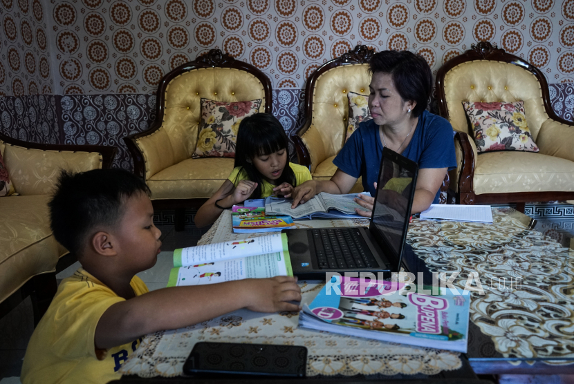 Siswa mengerjakan tugas didampingi ibunya dirumahnya, di  Palangkaraya, Kalimantan Tengah, Selasa (14/4/2020). Pembelajaran jarak jauh (PJJ) tidak mudah bagi banyak orang tua dan murid, sebab sejumlah kendala,