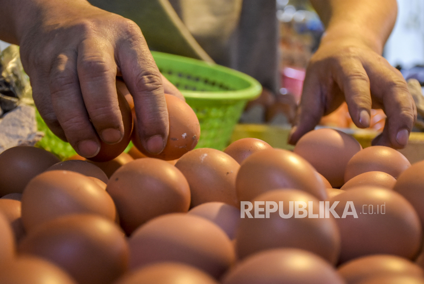 Pedagang menata telur ayam di kiosnya di Pasar Kosambi, Kota Bandung, Rabu (29/12/2021). Harga telur ayam mengalami kenaikan sejak beberapa pekan terakhir. Foto: Republika/Abdan Syakura