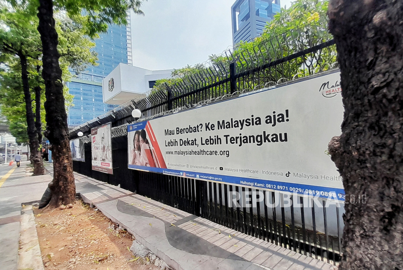 Spanduk berisi ajakan berobat di negara Malaysia terpasang di depan gedung Kedutaan Besar Malaysia untuk Indonesia, Jakarta, Rabu (9/10/2024).