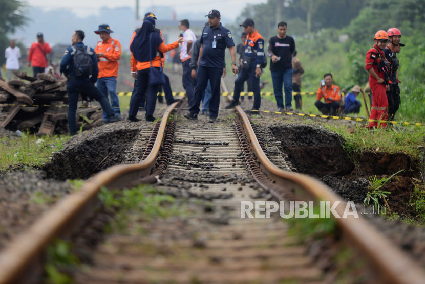 Petugas melihat kondisi jalur rel kereta api Bogor-Sukabumi yang longsor di kawasan Empang, Kota Bogor, Jawa Barat. KAI Daop 1 Jakarta membatalkan seluruh perjalanan KA Pangrango, Sabtu (1/7/2023).