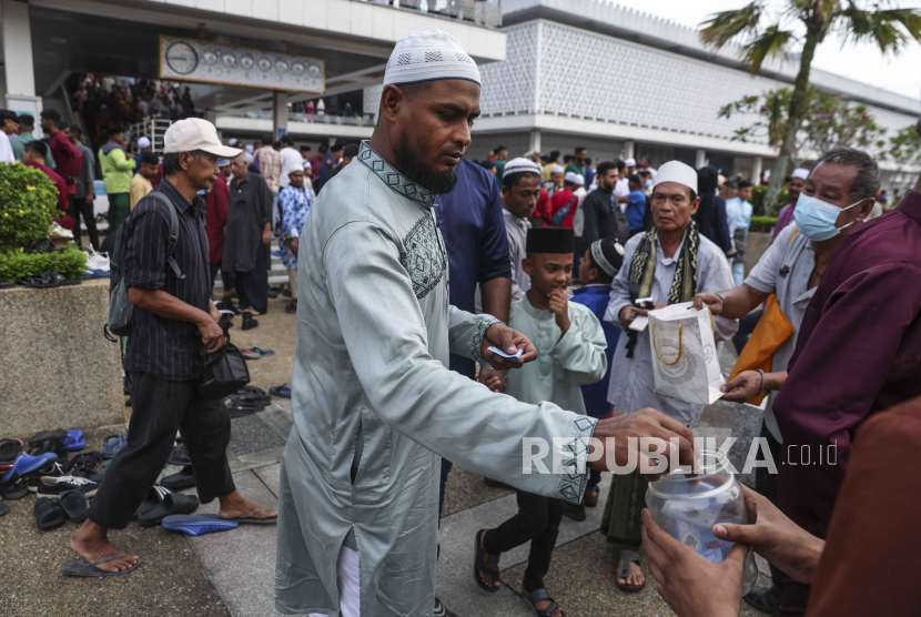 Seorang pria menyumbangkan uang untuk amal setelah mengikuti sholat Idul Fitri di Masjid Nasional di Kuala Lumpur, Malaysia, 10 April 2024.