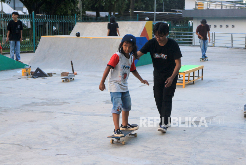 Seorang anak belajar bermain papan seluncur atau skateboard di taman bermain skateboard (skatepark), Cibinong, Kabupaten Bogor, Jawa Barat, Selasa (21/6/2022). Masih banyak anak Indonesia yang kurang melakukan aktivitas fisik harian sesuai rekomendasi.