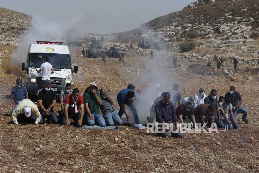  Tentara Israel menembakkan gas air mata ke arah warga Palestina selama sholat selama demonstrasi menentang permukiman Israel di desa Be Dajan dekat kota Nablus, Tepi Barat utara,  Jumat (9/10/2020). 