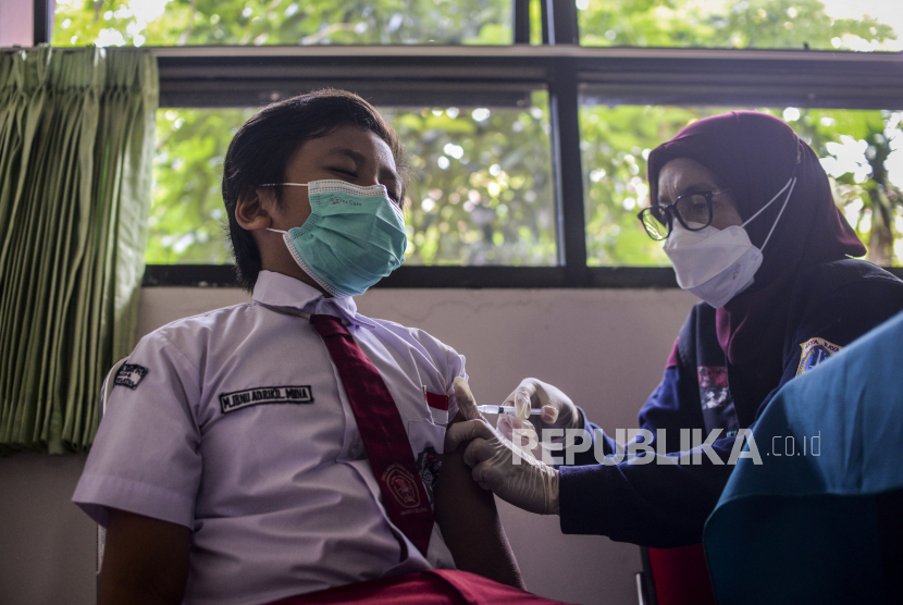 Tenaga kesehatan menyuntikan vaksin Covid-19 kepada seorang anak di SDN Cilandak Barat 04, Jakarta, Selasa (14/12). Kementerian Kesehatan memulai vaksinasi Covid-19 untuk anak usia enam hingga sebelas tahun dengan jumlah sasaran vaksinasi mencapai 26,5 juta di Indonesia. Republika/Putra M. Akbar