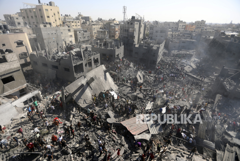 Warga memeriksa puing-puing bangunan yang hancur akibat serangan udara Israel di kota Khan Younis, Jalur Gaza, Palestina, Kamis,  (26/10/2023).