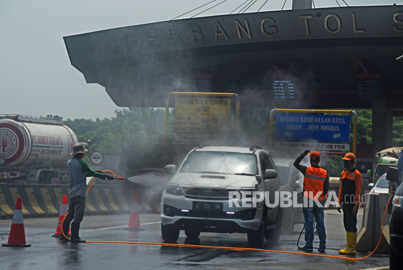 Sejumlah petugas menyemprotkan cairan disinfektan ke kendaraan yang keluar di Pintu Tol Serang Timur, di Serang, Banten, Minggu (19/4/2020). Pemda setempat memberlakukan pemeriksaan kesehatan bagi setiap orang dan penyemprotan disinfektan setiap kendaraan yang akan memasuki kota Serang untuk mencegah penyebaran COVID-19