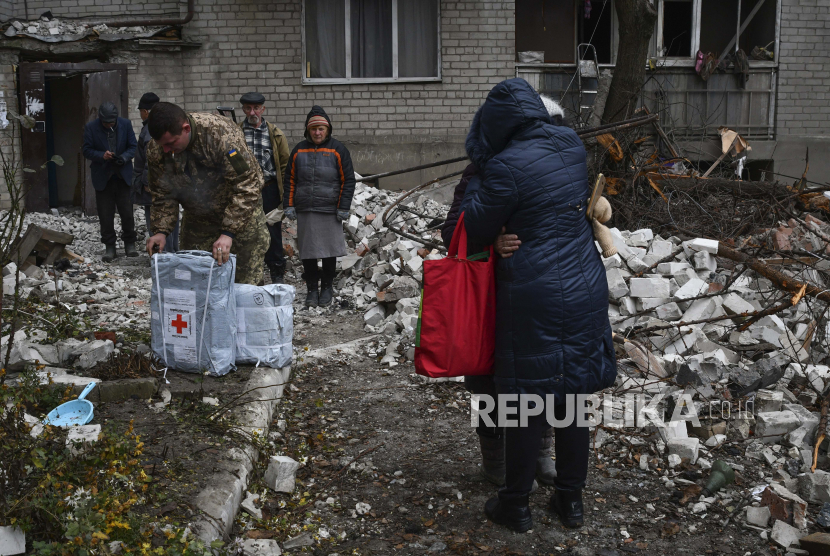 Penduduk setempat bereaksi di dekat rumah yang hancur setelah serangan udara Rusia baru-baru ini di Chasiv Yar, Ukraina, Ahad, 27 November 2022.