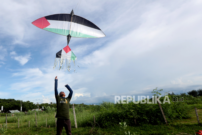 Peserta menerbangkan layang-layang tunang bermotif bendera Palestina.