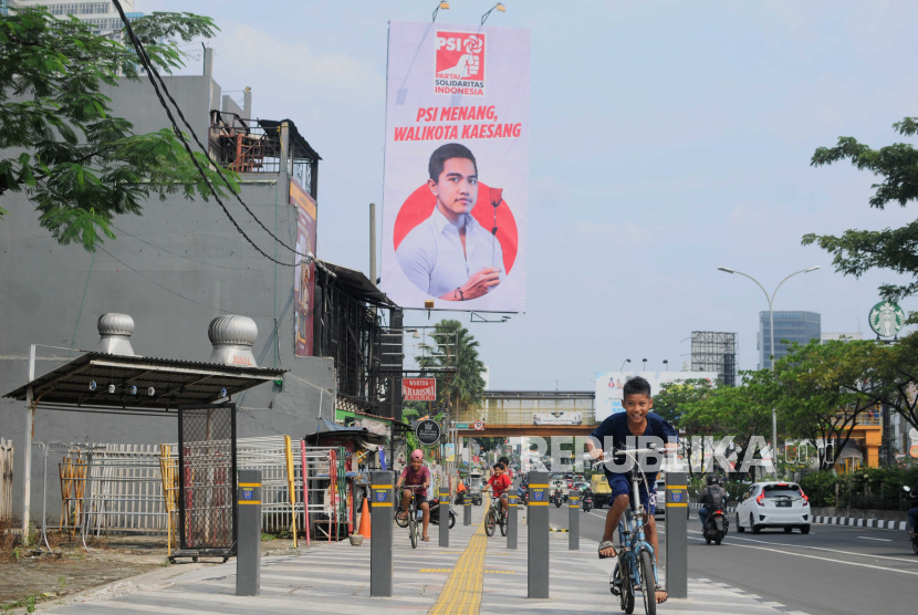 Anak-anak bersepeda di dekat baliho bergambar putra Presiden Joko Widodo, Kaesang Pangarep di Jalan Margonda Raya, Kota Depok, Jawa Barat, Selasa (23/5/2023). Relawan Ganjar sebut nama Kaesang muncul menjadi bukti warga Depok butuh perubahan.