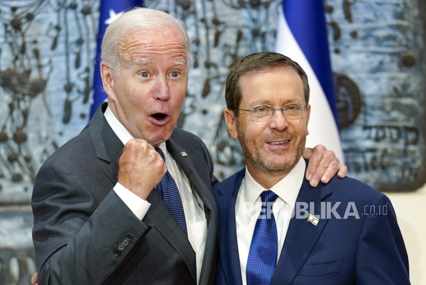  Presiden Joe Biden bereaksi saat dia berdiri dengan Presiden Israel Isaac Herzog. 