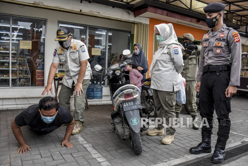 Petugas gabungan memberi hukuman push up kepada warga yang tidak mengenakan masker saat operasi gabungan patroli pengawasan dan penegakan disiplin (Gakplin) protokol kesehatan Covid-19 di Antapani Kidul, Kecamatan Antapani, Kota Bandung, Rabu (10/2). Operasi tersebut digelar dalam rangka pemberlakuan pembatasan kegiatan masyarakat (PPKM) skala mikro guna menertibkan masyarakat agar lebih disiplin dalam menerapkan protokol kesehatan Covid-19 serta mencegah penyebaran Covid-19 di tingkat desa atau kelurahan. Foto: Abdan Syakura/Republika