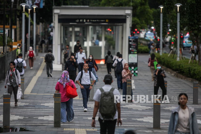 Pekerja berjalan di Jalan Jenderal Sudirman, Jakarta, Kamis (15/2/2024). 