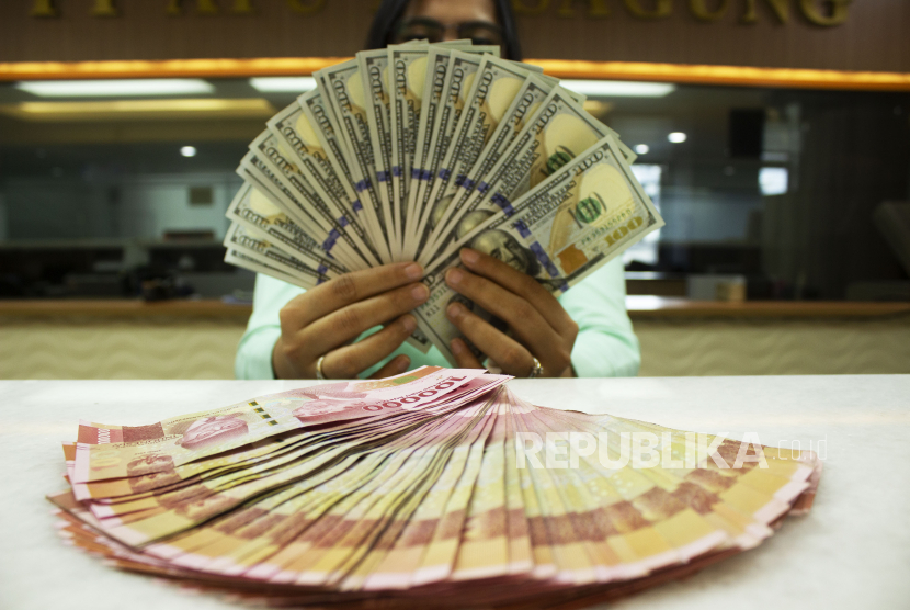Teller memegang mata uang Dolar AS dan Rupiah di sebuah tempat penukaran uang, Jakarta, Rabu (6/7/2022). 