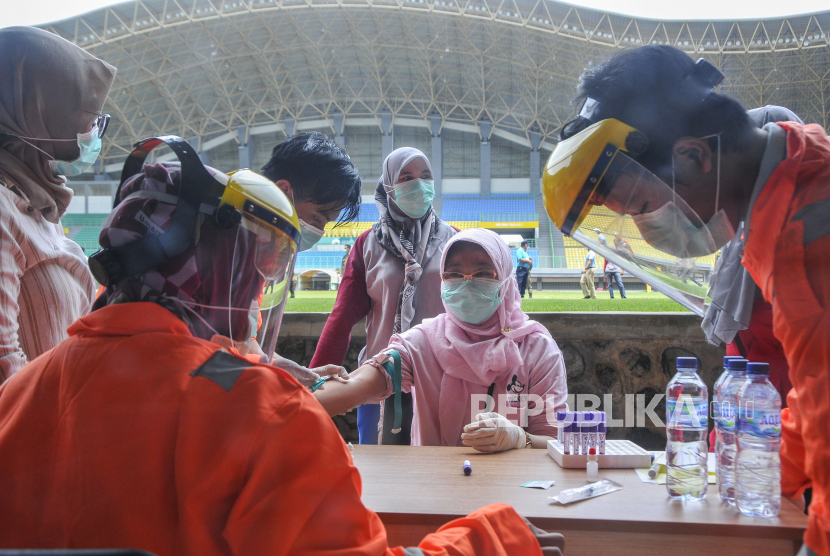 Petugas medis mengecek kesehatannya dengan mengambil sampel  darah dengan metode rapid test (pemeriksaan cepat) di Stadion Patriot Candrabhaga, Bekasi, Jawa Barat, Rabu (25/3/2020). Pemeriksaan yang dilakukan khusus tenaga medis di Bekasi guna memutus mata rantai penyebaran virus COVID-19