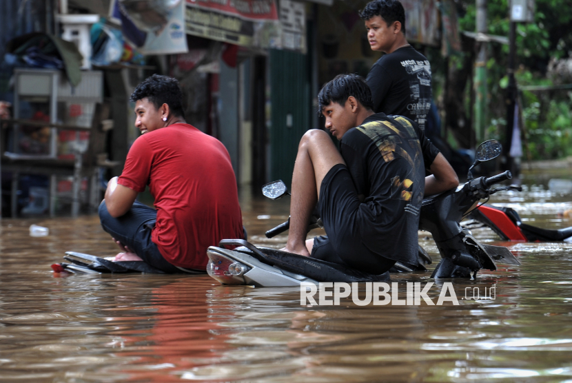 Warga beraktivitas saat banjir yang merendam pemukiman di kawasan Rawajati, Jakarta, Selasa (4/3/2025). Berdasarkan data BPBD DKI Jakarta mencatat, sebanyak 59 RT di kawasan Rawajati dan Cililitan terendam banjir dengan ketinggian mulai dari 30-300 centimeter yang disebabkan oleh meluapnya kali Ciliwung.