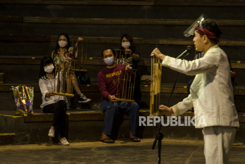 Pemain Angklung menghibur wisatawan saat pertunjukan di Saung Angklung Udjo, Bandung, Jawa Barat, Ahad (29/11/2020). Alat musik sekaligus karya seni tradisional asal Jabar, angklung, pada tahun 2020 telah satu dekade diakui UNESCO sebagai warisan budaya dunia kategori Tak Benda sejak dikukuhkan pada November 2010 lalu. 