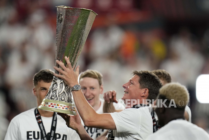  Pelatih kepala Frankfurt Oliver Glasner merayakan dengan trofi setelah memenangkan pertandingan sepak bola final Liga Eropa antara Eintracht Frankfurt dan Rangers FC di stadion Ramon Sanchez Pizjuan di Seville, Spanyol, Kamis (19/5/2022) dini hari WIB.