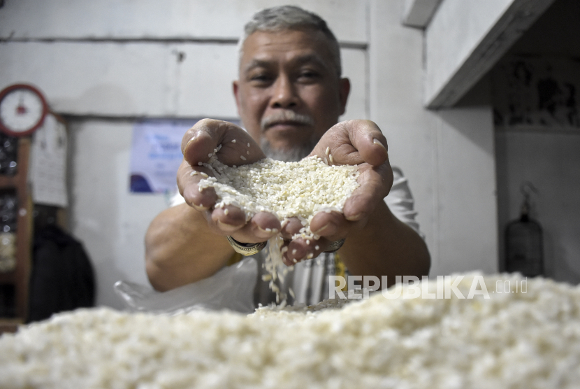 Pedagang menunjukkan beras yang dijual di kiosnya di Pasar Kosambi, Kota Bandung, Rabu (25/1/2023). Pedagang di pasar tersebut menyatakan, dalam beberapa bulan terakhir harga beras mengalami kenaikan mulai dari Rp1.000 hingga Rp2.000. Harga beras dengan kualitas medium menjadi Rp12 ribu dari yang semula Rp10ribu dan beras kualitas premium menjadi Rp15 ribu dari harga Rp12.500.